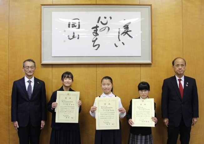 令和7年度児童作品表彰式の様子、市長と水道事業管理者と受賞生徒の記念写真