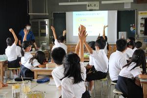 出前授業で児童が質問に手を挙げている写真