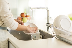 台所で洗い物をしている女性の写真