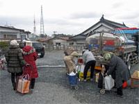 ポリタンクを持った市民たちが給水車にて給水をしている写真